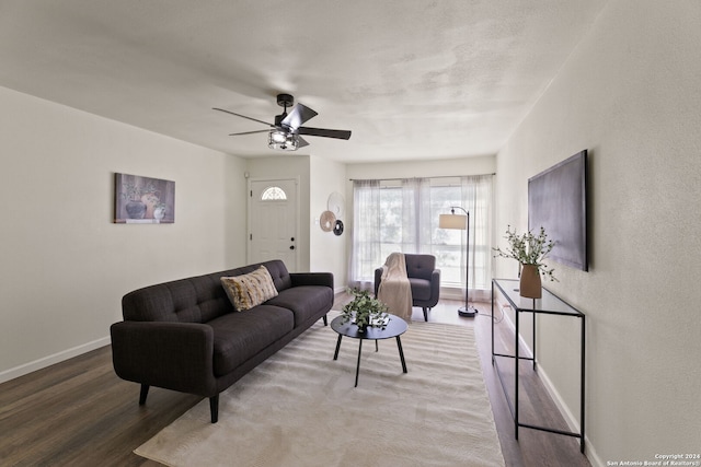 living room featuring ceiling fan, wood finished floors, and baseboards