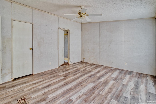 225 County Road 3821, San Antonio, TX 78253 - unfurnished bedroom with a textured ceiling, light wood-style flooring, and a ceiling fan
