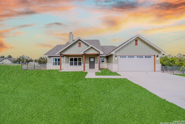 craftsman inspired home with a garage, driveway, board and batten siding, and a yard