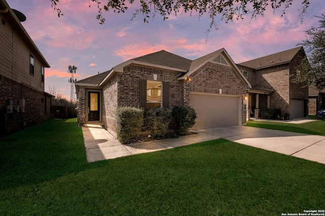 view of front facade with a yard, concrete driveway, brick siding, and an attached garage