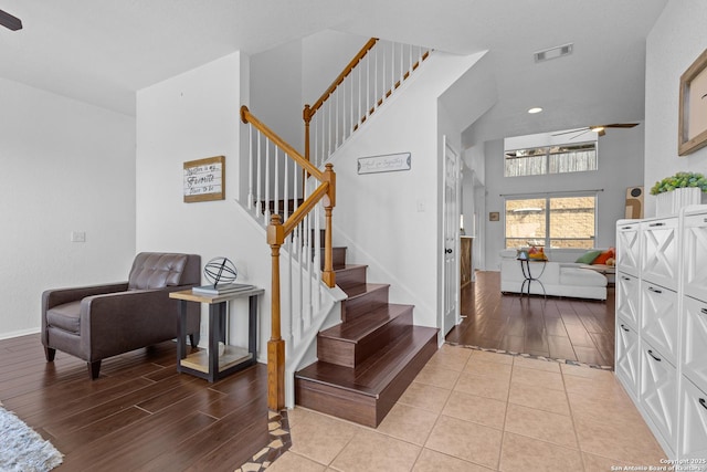 entryway with a towering ceiling, stairway, light wood-style flooring, and visible vents