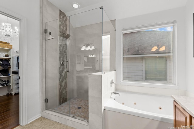 full bathroom featuring a shower stall, a tub with jets, and vanity