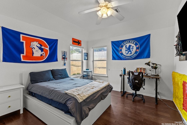 bedroom with dark wood-style floors, ceiling fan, visible vents, and baseboards