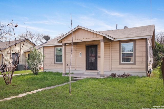 bungalow-style house with central AC unit, board and batten siding, and a front yard