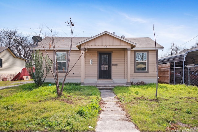 bungalow-style house featuring board and batten siding, a front yard, and fence