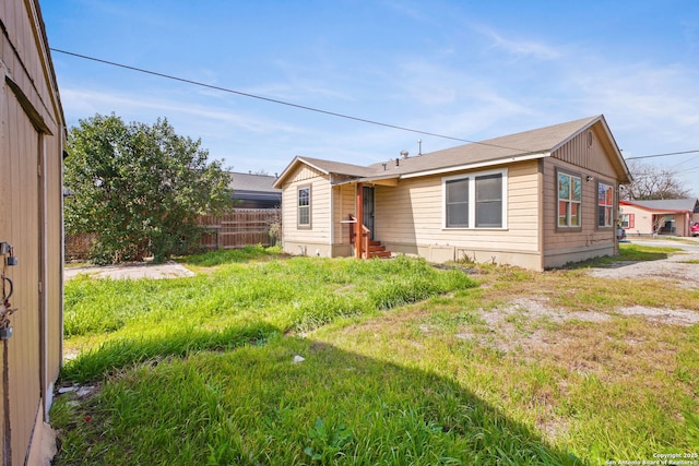 view of front of property with entry steps, fence, and a front yard