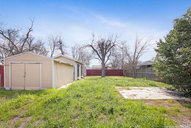 view of yard with a fenced backyard, a storage unit, and an outdoor structure