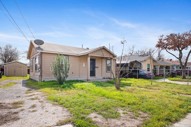 view of front of property with covered porch, fence, an outdoor structure, and a storage unit