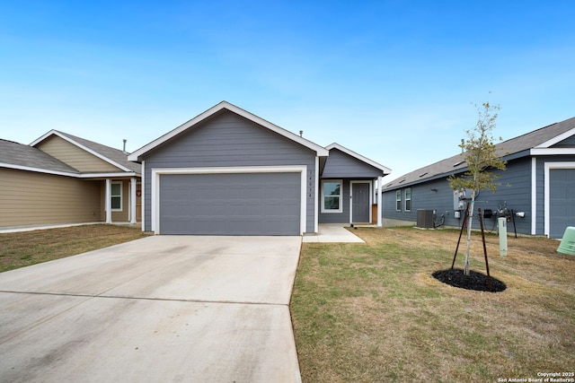 ranch-style home featuring a garage, a front yard, driveway, and central AC unit