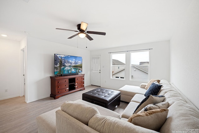 living room with baseboards, ceiling fan, and light wood-style floors