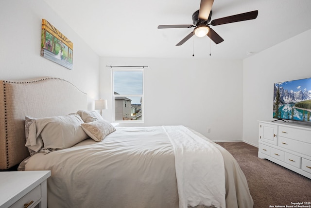 bedroom featuring dark colored carpet, a ceiling fan, and baseboards