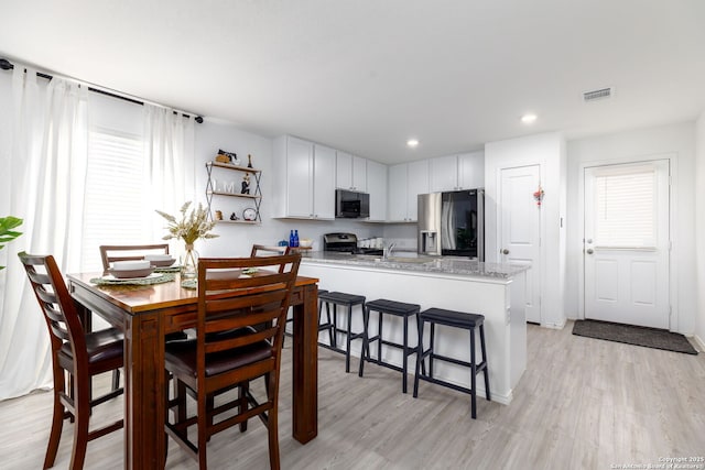 dining space with recessed lighting, visible vents, and light wood-style floors