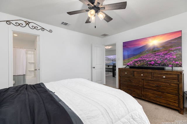 bedroom with visible vents, ceiling fan, light carpet, and ensuite bath