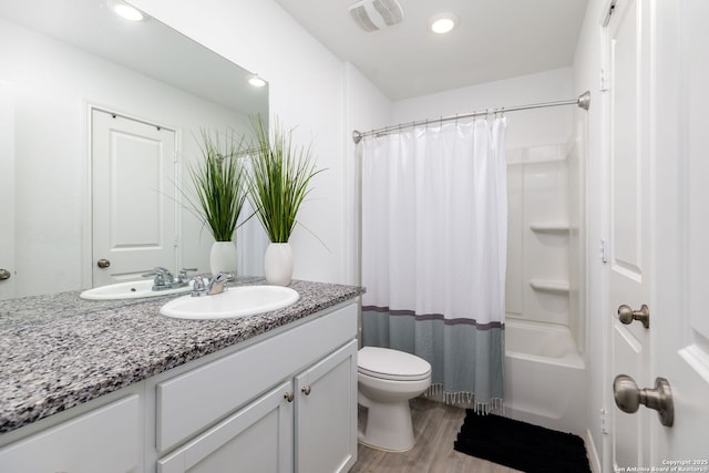 full bathroom featuring toilet, wood finished floors, vanity, visible vents, and shower / bath combination with curtain