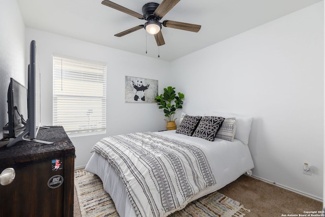 carpeted bedroom with a ceiling fan and baseboards