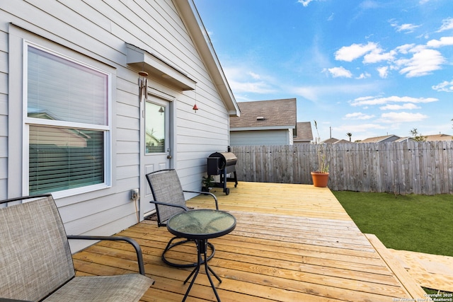 wooden terrace with a yard, fence, and grilling area