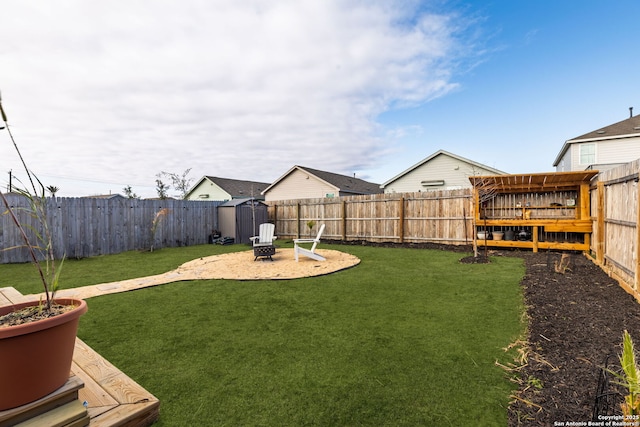 view of yard featuring an outdoor fire pit, a fenced backyard, and a shed