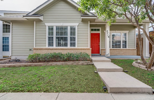 bungalow-style home featuring a front yard and brick siding