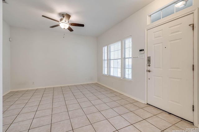 entrance foyer featuring a ceiling fan, light tile patterned flooring, and baseboards