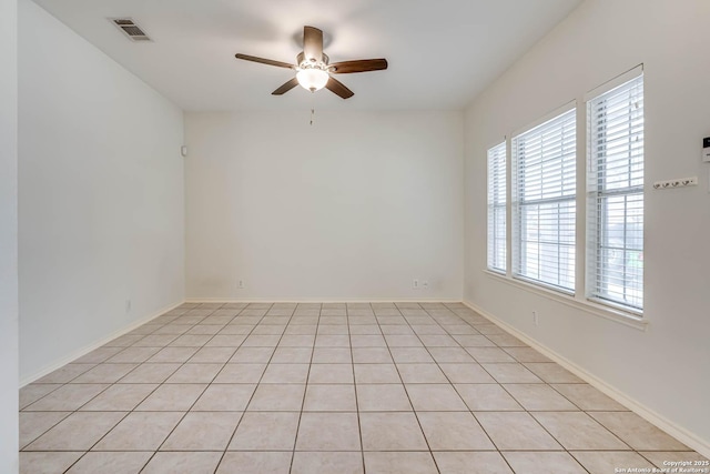 unfurnished room with baseboards, visible vents, and a ceiling fan