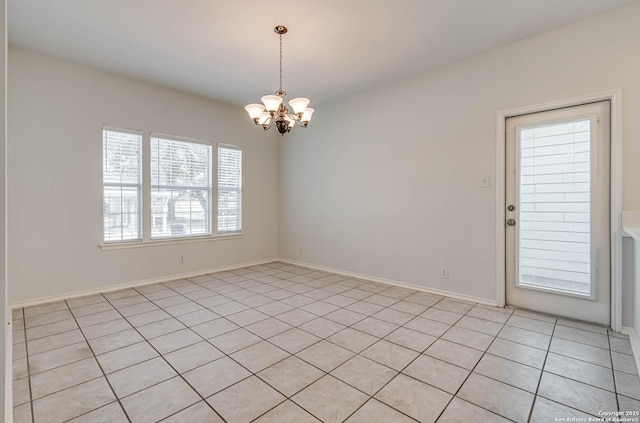 unfurnished room with a chandelier and baseboards