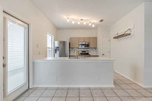 kitchen with tasteful backsplash, visible vents, stainless steel appliances, light countertops, and a sink