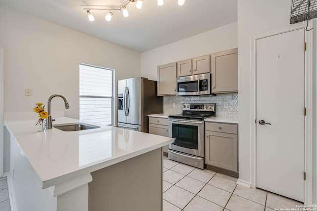 kitchen featuring a sink, stainless steel appliances, a peninsula, and light countertops