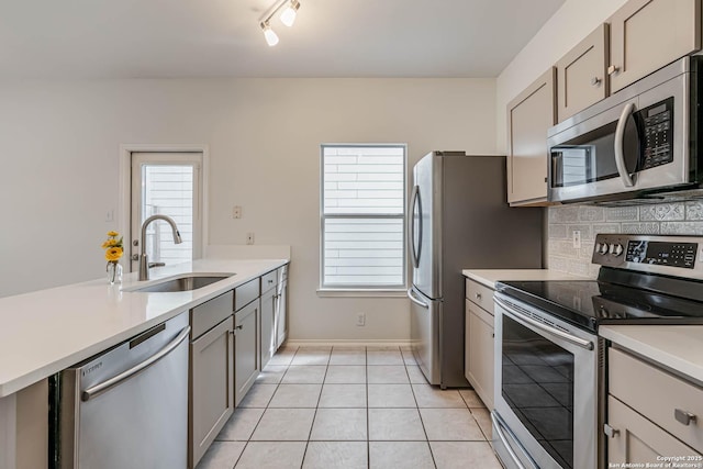 kitchen with stainless steel appliances, light countertops, and a sink