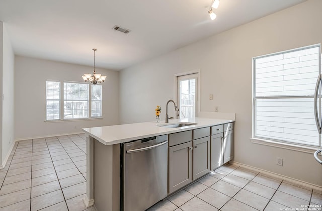 kitchen featuring visible vents, hanging light fixtures, light countertops, stainless steel dishwasher, and a sink