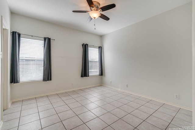 spare room featuring a ceiling fan and baseboards