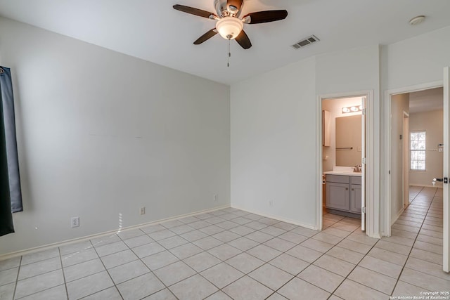 spare room featuring baseboards, visible vents, ceiling fan, a sink, and light tile patterned flooring