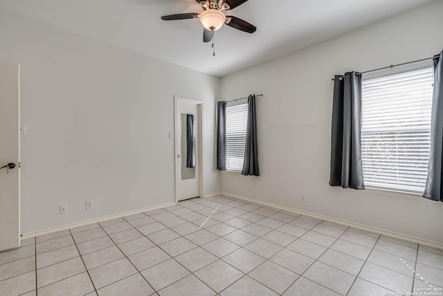 empty room featuring a ceiling fan and baseboards