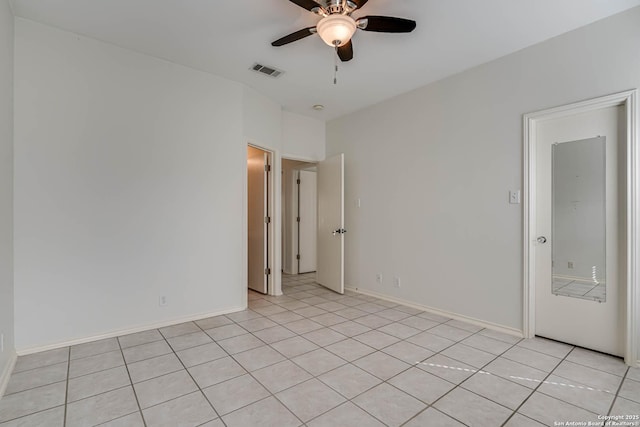 spare room featuring a ceiling fan, visible vents, baseboards, and light tile patterned floors