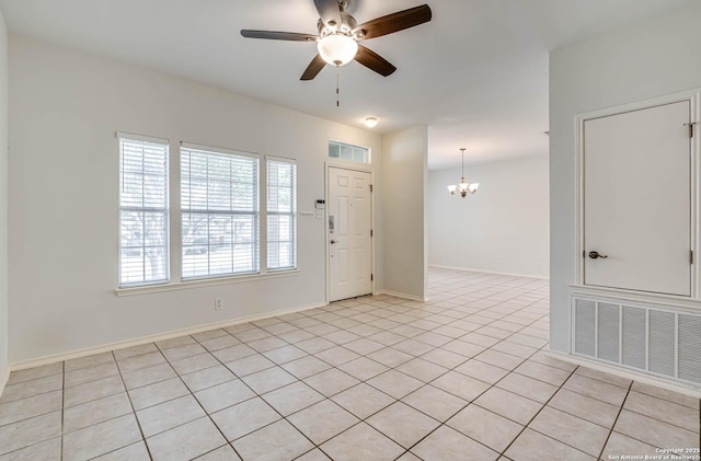 unfurnished room with light tile patterned flooring, baseboards, visible vents, and ceiling fan with notable chandelier