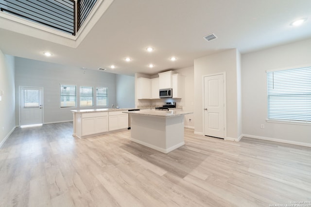 kitchen featuring light stone countertops, visible vents, appliances with stainless steel finishes, and white cabinets