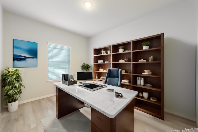 home office with baseboards and light wood finished floors