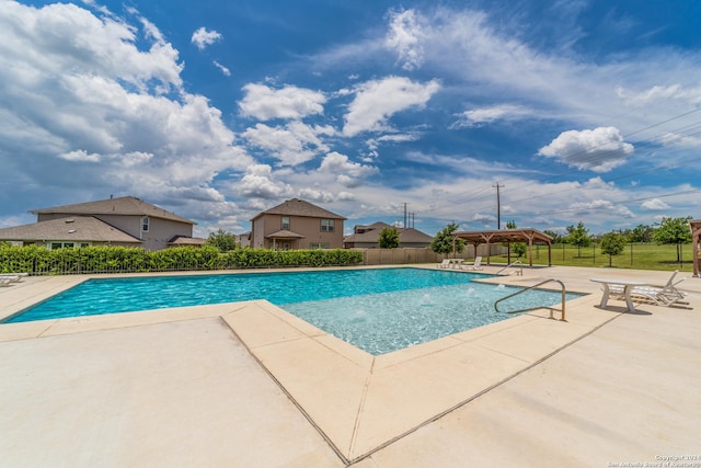 community pool with a gazebo, a patio, and fence