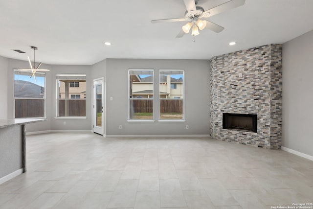 unfurnished living room with a large fireplace, ceiling fan, plenty of natural light, and visible vents