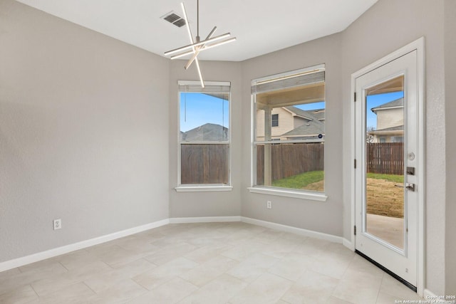 unfurnished dining area with an inviting chandelier, visible vents, and baseboards