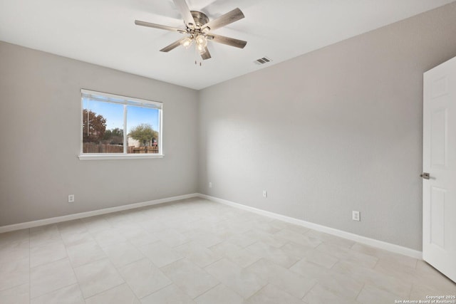 empty room featuring a ceiling fan, visible vents, and baseboards