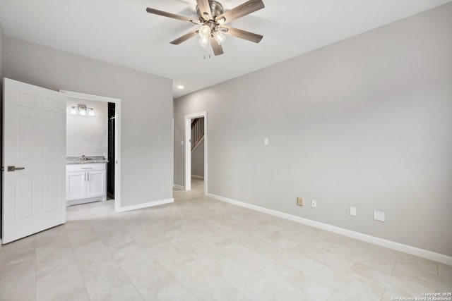 unfurnished bedroom with baseboards, a ceiling fan, and ensuite bathroom