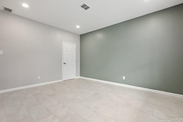 empty room with recessed lighting, visible vents, and baseboards