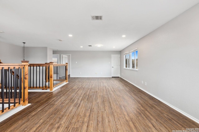 empty room featuring recessed lighting, visible vents, dark wood finished floors, and baseboards