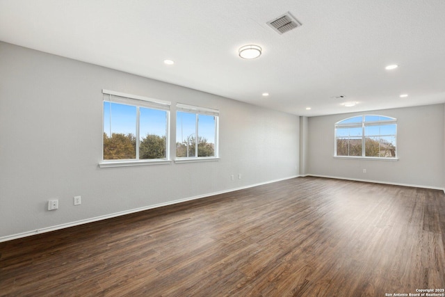 spare room with baseboards, visible vents, dark wood finished floors, and recessed lighting