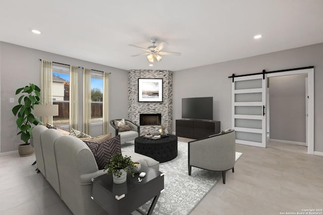 living area featuring a barn door, recessed lighting, a large fireplace, a ceiling fan, and baseboards