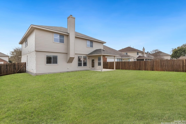 back of property featuring a patio area, a lawn, a chimney, and a fenced backyard