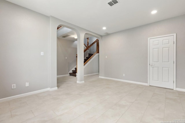 spare room with stairway, visible vents, arched walkways, and recessed lighting