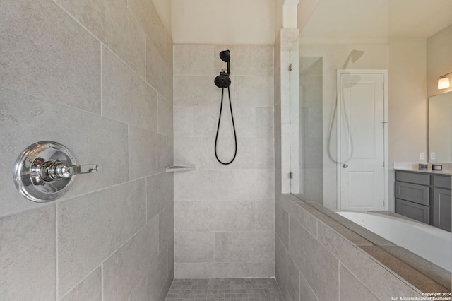 bathroom with a tile shower and vanity