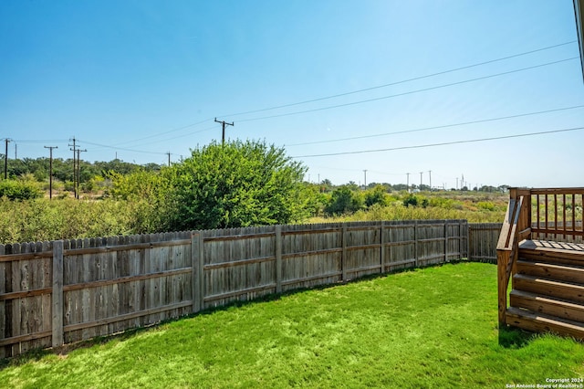 view of yard with a fenced backyard and stairs