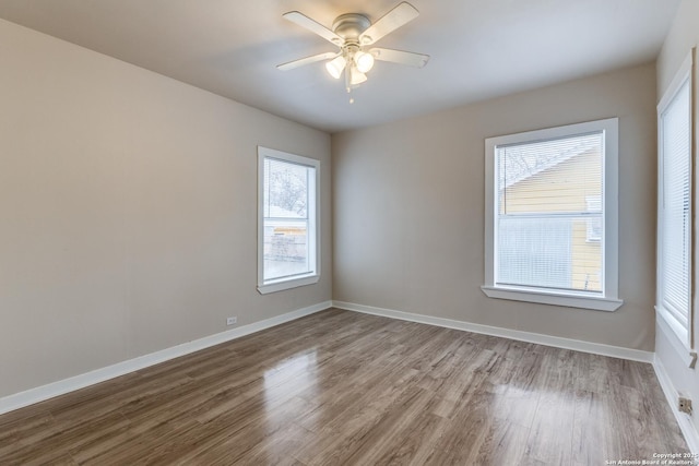 spare room with ceiling fan, baseboards, and wood finished floors